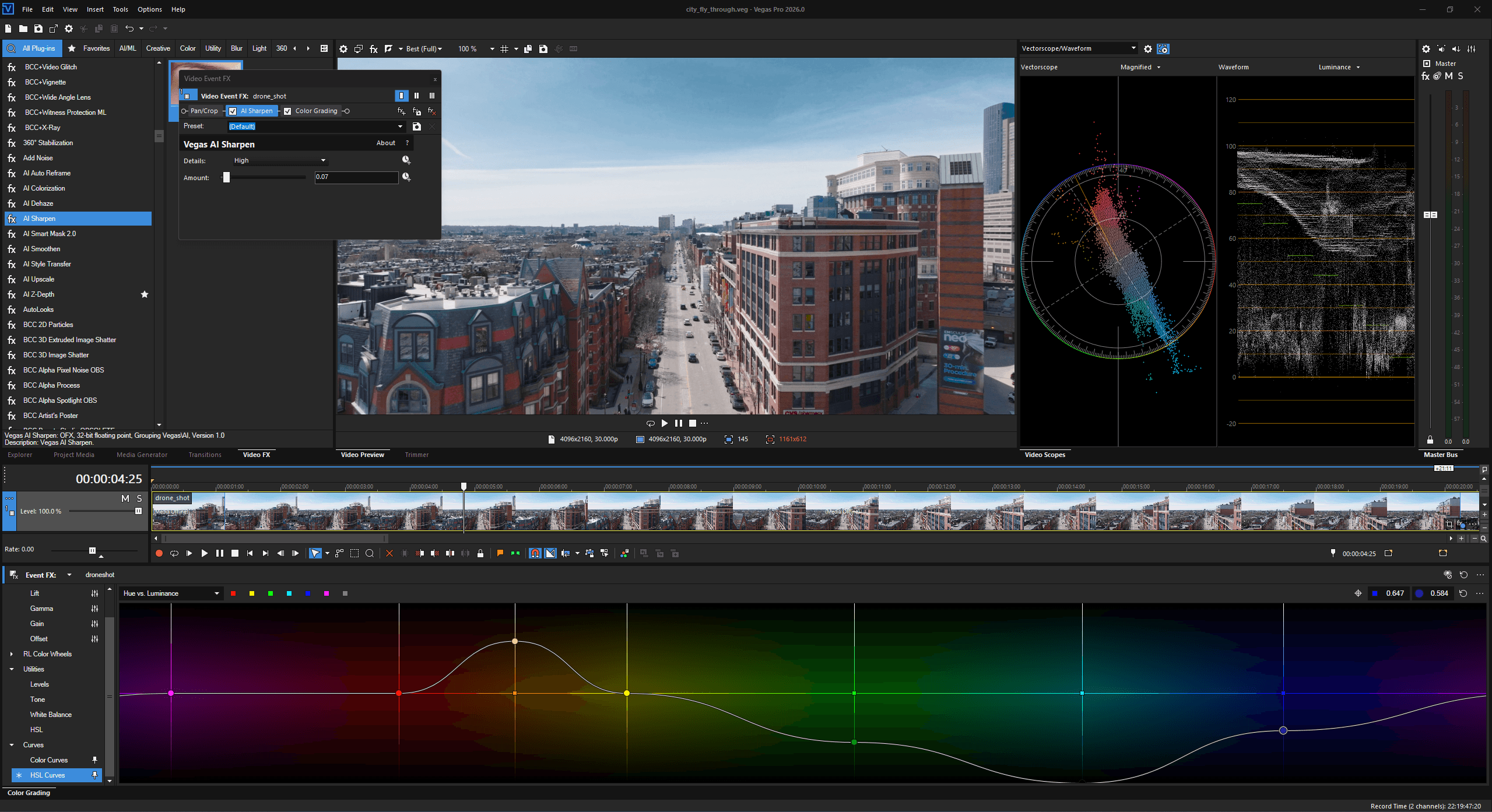Vegas Pro editing interface with city drone-shot footage in the preview, color grading and scopes panels open, timeline at bottom