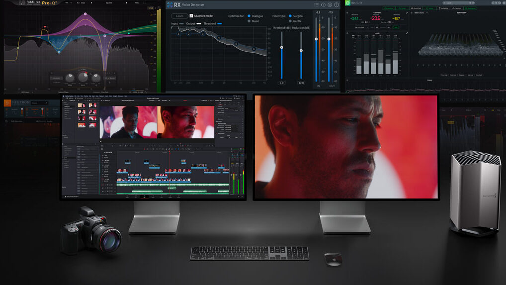 Studio workstation with dual monitors running video editing software, a camera on the left, and a silver desktop tower on the right.
